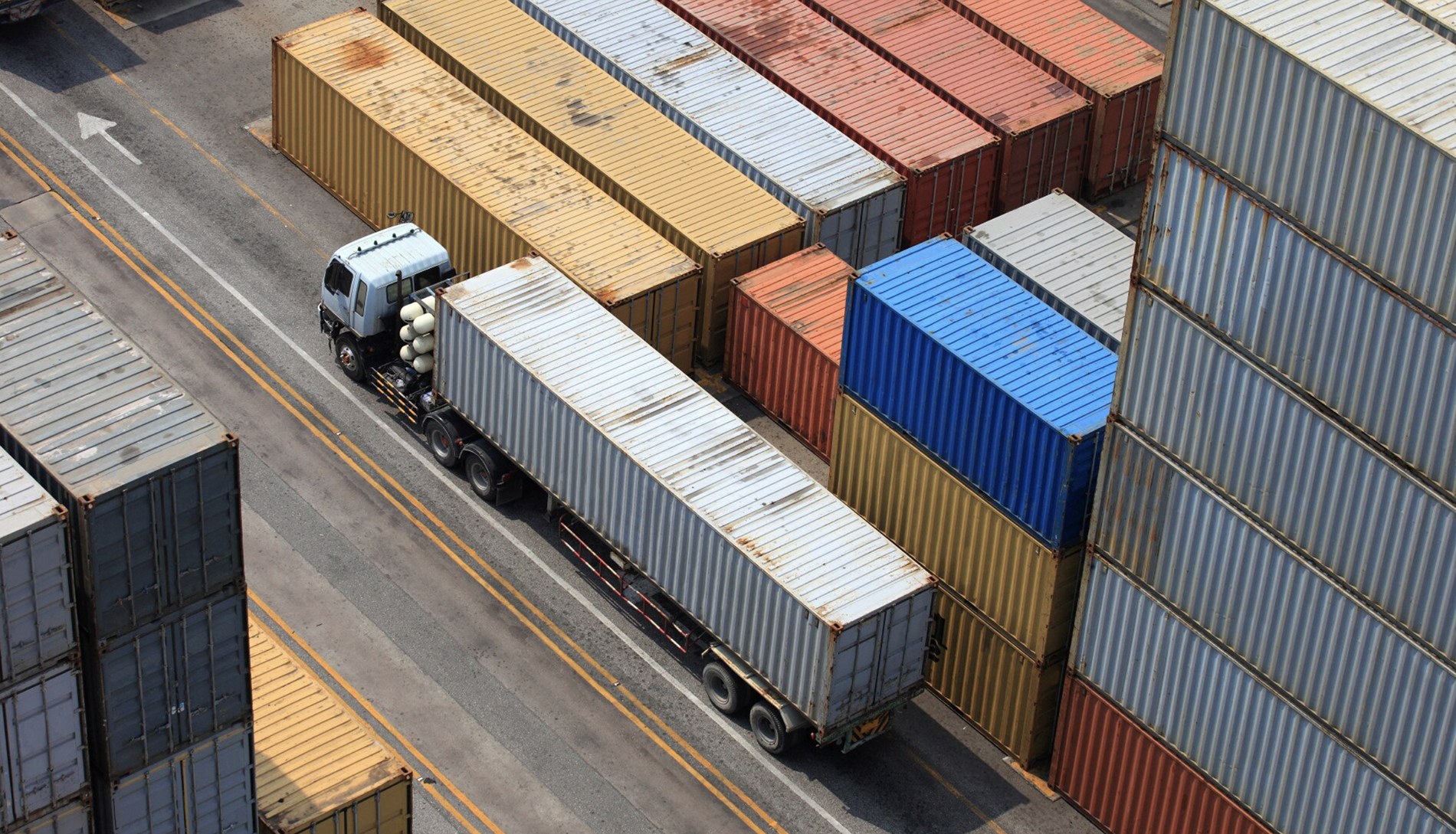 Terminal kontena dengan kren gantri mengangkat kontena penghantaran ke trak halaman